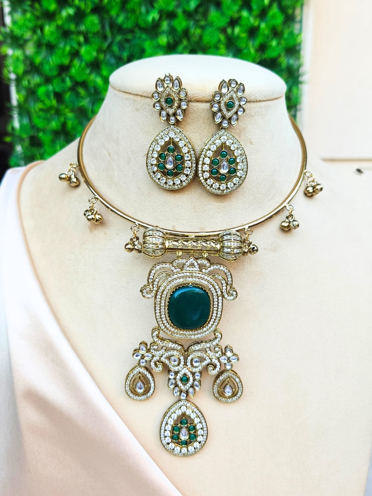 Discover the elegance of the Lupin Hasli Necklace Set, featuring a radiant Dark Green Monalisa stone, sparkling American diamonds, and charming tiny ghungroos. Perfect for saris, weddings, and festive occasions. Put on a white mannequin, and a beige embroidered fabric draped over the shoulder