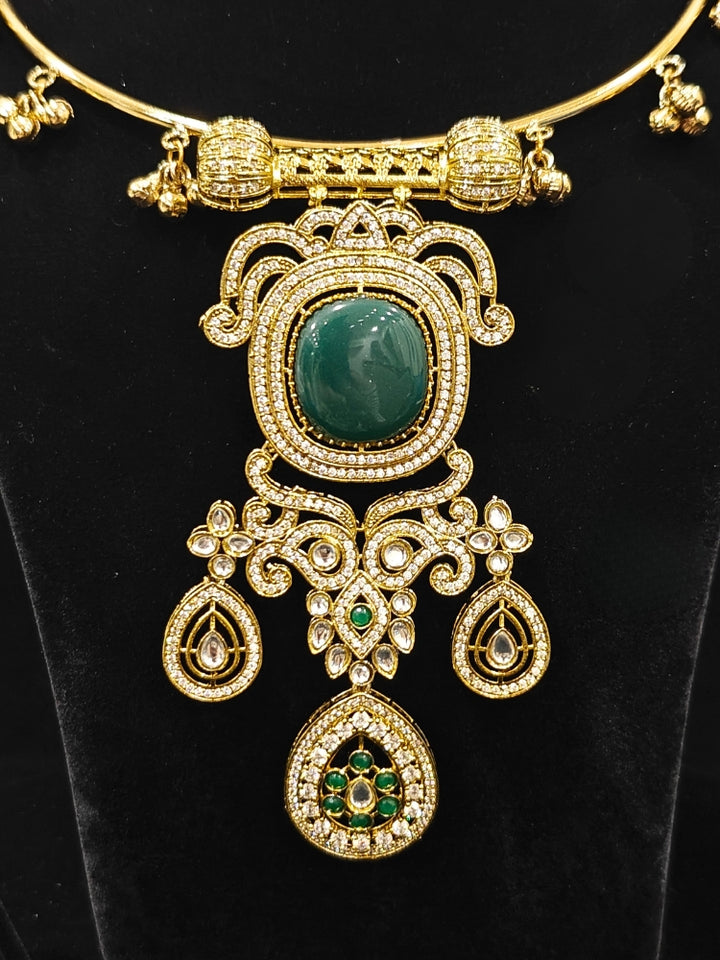 Close-up of an ornate Traditional Dark Green Diamond (Mehendi gold Polish) Hasli jewellery set and earrings with American Diamond and Dark Green Colored Stones. A luxury American diamond necklace set styled beautifully for a wedding guest look in India. Elegant festive look with a high-quality imitation American diamond necklace set.