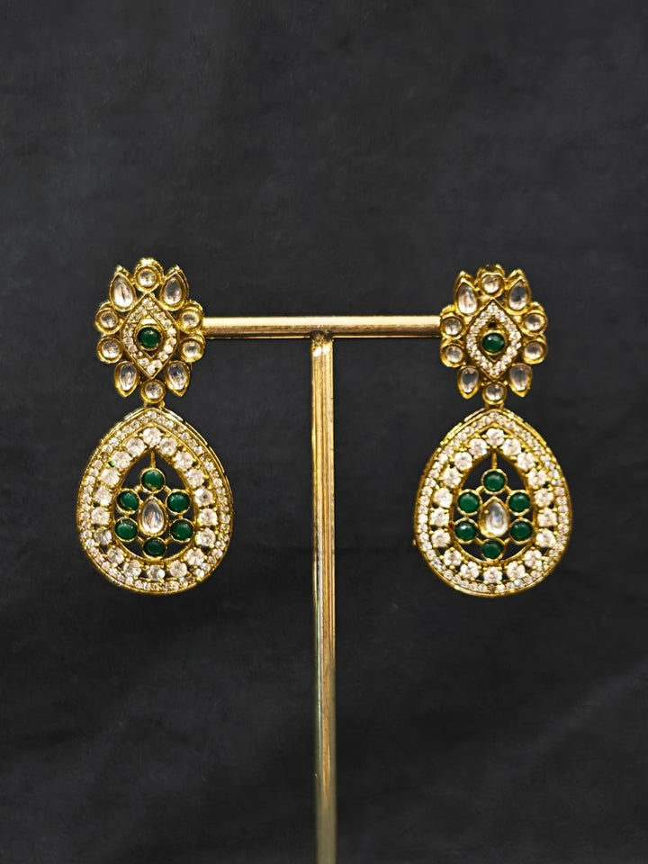 Close-up of an ornate Traditional Dark Green Diamond (Mehendi gold Polish) Hasli jewellery set and earrings with American Diamond and Dark Green Colored Stones. A luxury American diamond necklace set styled beautifully for a wedding guest look in India. Elegant festive look with a high-quality imitation American diamond necklace set.