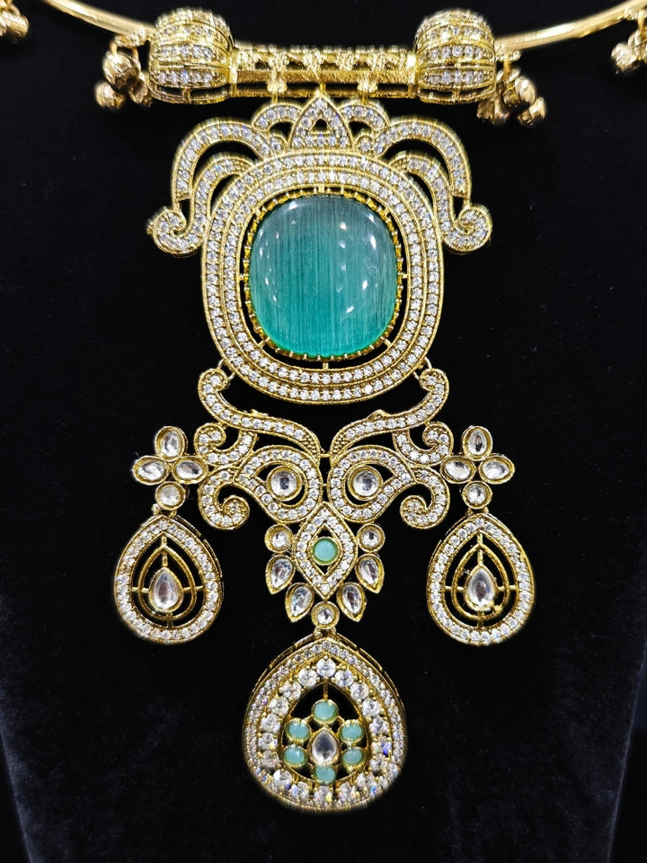Close-up of an ornate Traditional Mint Blue Diamond (Mehendi gold Polish) Hasli jewellery set and earrings with American Diamond and Mint Blue Colored Stones. A  luxury American diamond necklace set styled beautifully for a wedding guest look in India. Elegant festive look with a high-quality imitation American diamond necklace set.