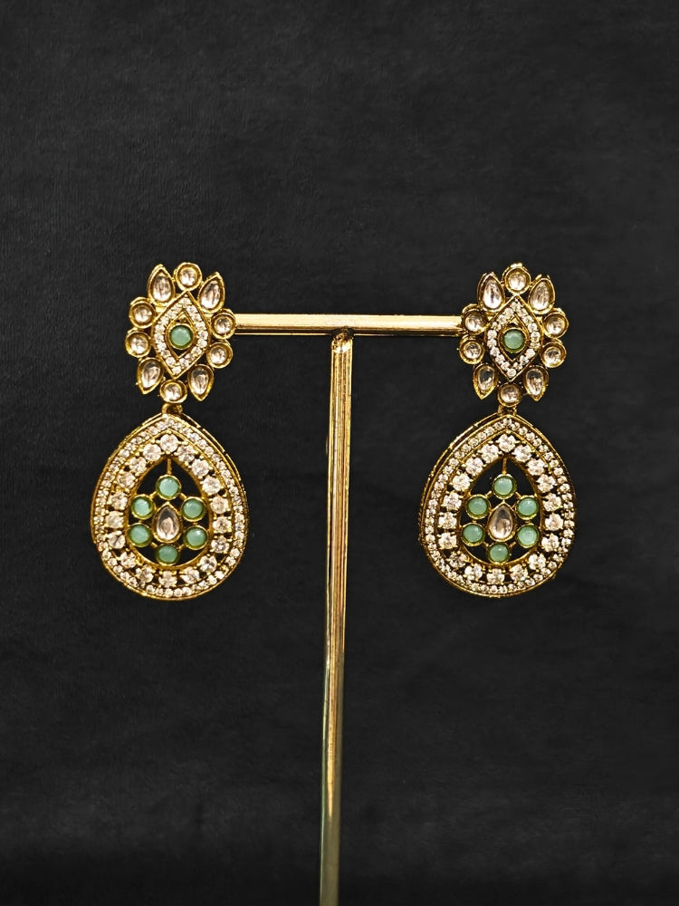 Close-up of an ornate Traditional Mint Blue Diamond (Mehendi gold Polish) Hasli jewellery set and earrings with American Diamond and Mint Blue Colored Stones. A  luxury American diamond necklace set styled beautifully for a wedding guest look in India. Elegant festive look with a high-quality imitation American diamond necklace set.