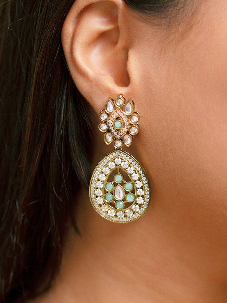 A beautiful woman wearing an elegant artificial diamond hasli necklace with mint green colored stone and matching earrings. This premium artificial diamond jewelry set is perfect for special occasions, from Indian weddings to engagement parties, offering sophisticated glamour without the high price tag.