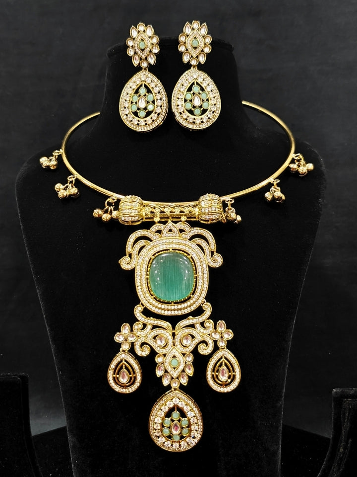 Close-up of an ornate Traditional Mint Green Diamond (Mehendi gold Polish) Hasli jewellery set and earrings with American Diamond and Mint Green Colored Stones. A luxury American diamond necklace set styled beautifully for a wedding guest look in India. Elegant festive look with a high-quality imitation American diamond necklace set.