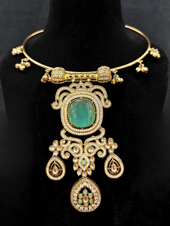 Close-up of an ornate Traditional Mint Green Diamond (Mehendi gold Polish) Hasli jewellery set and earrings with American Diamond and Mint Green Colored Stones. A luxury American diamond necklace set styled beautifully for a wedding guest look in India. Elegant festive look with a high-quality imitation American diamond necklace set.