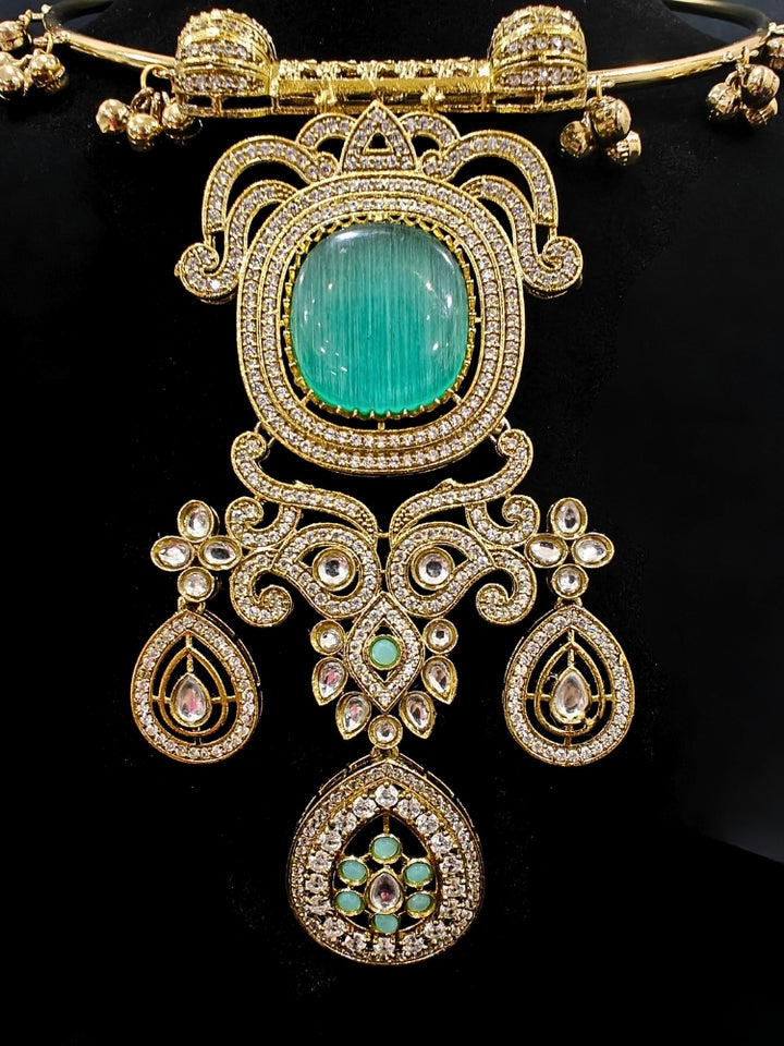 Close-up of an ornate Traditional Mint Green Diamond (Mehendi gold Polish) Hasli jewellery set and earrings with American Diamond and Mint Green Colored Stones. A luxury American diamond necklace set styled beautifully for a wedding guest look in India. Elegant festive look with a high-quality imitation American diamond necklace set.