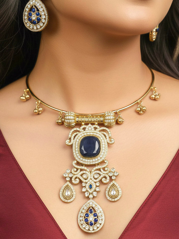 Close-up of a woman wearing an ornate Traditional Navy Blue Diamond (Mehendi gold Polish) Hasli jewellery set and earrings with American Diamond and Navy Blue Colored Stones. A woman wearing a luxury American diamond necklace set styled beautifully for a wedding guest look in India. Elegant festive look with a high-quality imitation American diamond necklace set.