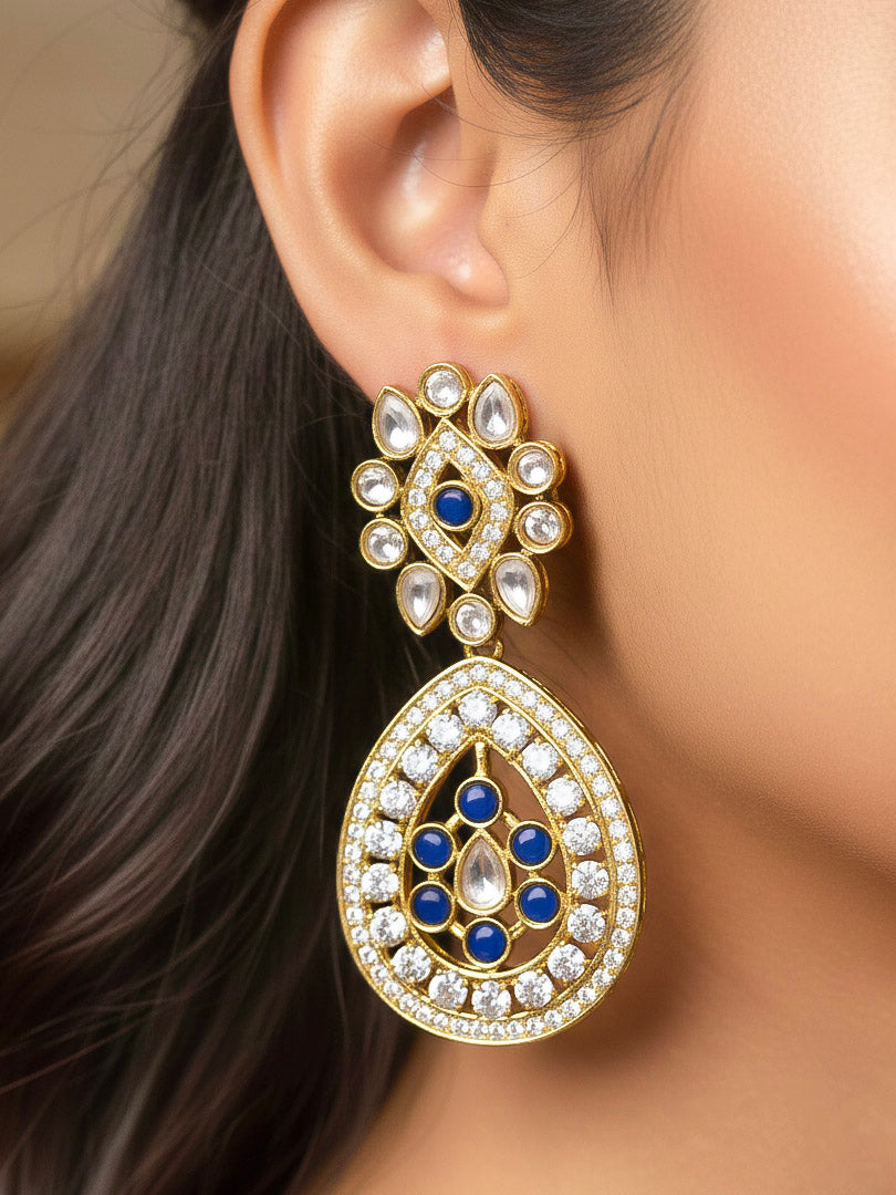 Close-up of a woman wearing an ornate Traditional Navy Blue Diamond (Mehendi gold Polish) Hasli jewellery set and earrings with American Diamond and Navy Blue Colored Stones. A woman wearing a luxury American diamond necklace set styled beautifully for a wedding guest look in India. Elegant festive look with a high-quality imitation American diamond necklace set.