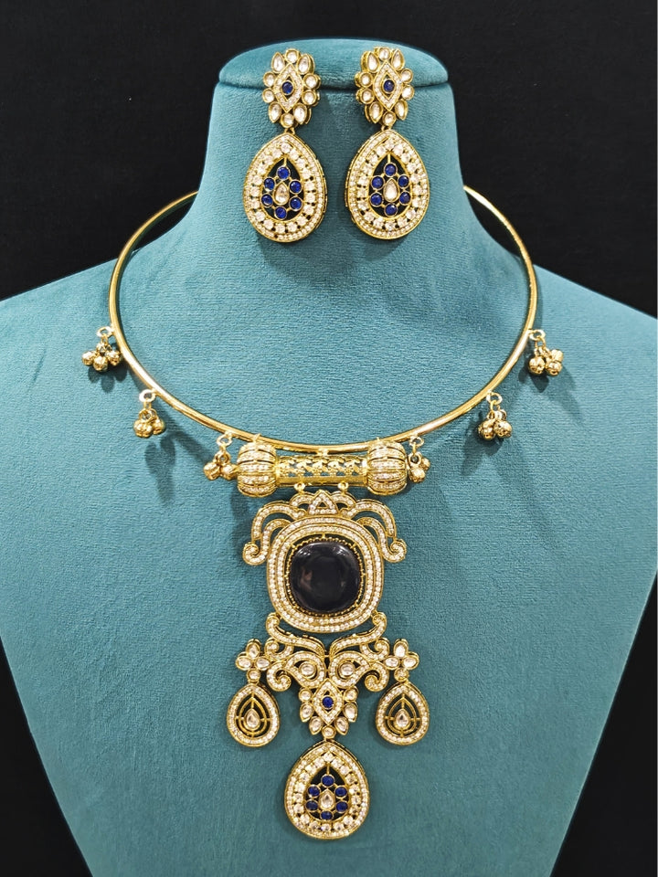 Close-up of an ornate Traditional Navy Blue Diamond (Mehendi gold Polish) Hasli jewellery set and earrings with American Diamond and Navy Blue Colored Stones. A  luxury American diamond necklace set styled beautifully for a wedding guest look in India. Elegant festive look with a high-quality imitation American diamond necklace set.