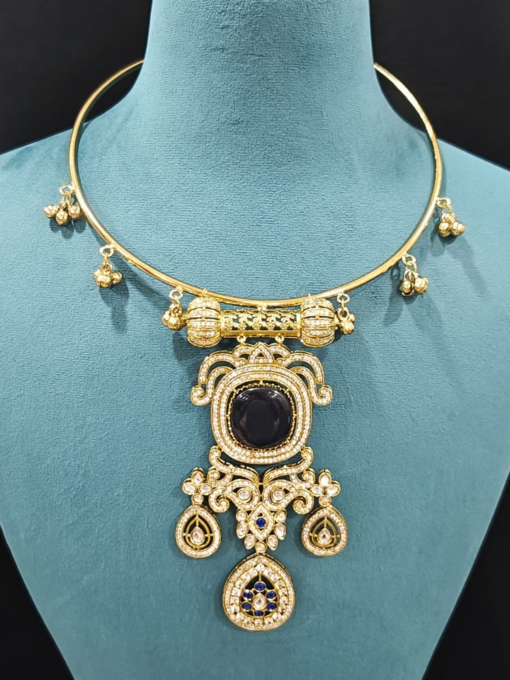 Close-up of an ornate Traditional Navy Blue Diamond (Mehendi gold Polish) Hasli jewellery set and earrings with American Diamond and Navy Blue Colored Stones. A  luxury American diamond necklace set styled beautifully for a wedding guest look in India. Elegant festive look with a high-quality imitation American diamond necklace set.