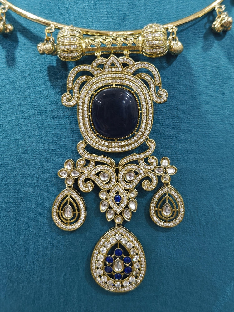 Close-up of an ornate Traditional Navy Blue Diamond (Mehendi gold Polish) Hasli jewellery set and earrings with American Diamond and Navy Blue Colored Stones. A  luxury American diamond necklace set styled beautifully for a wedding guest look in India. Elegant festive look with a high-quality imitation American diamond necklace set.