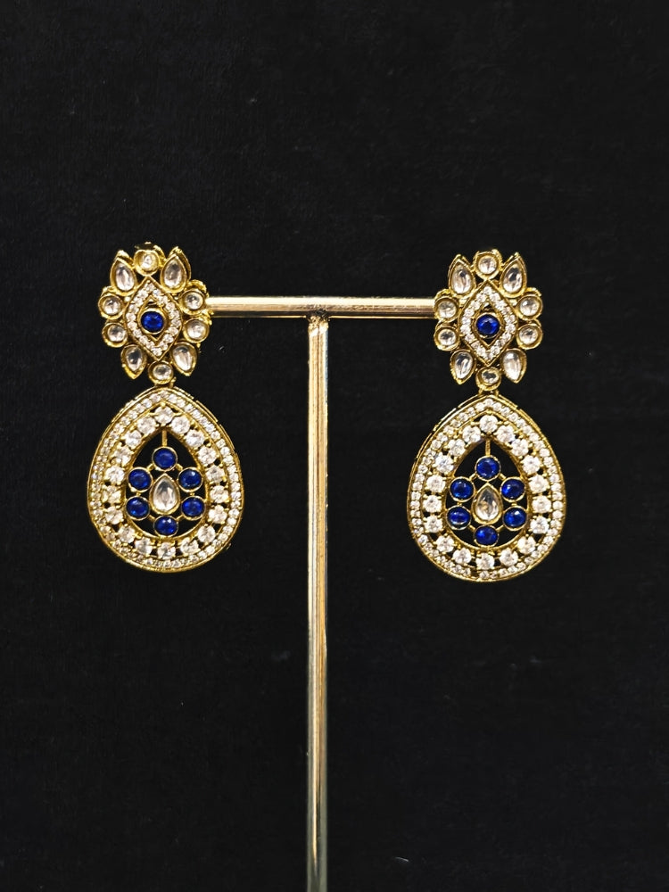 Close-up of an ornate Traditional Navy Blue Diamond (Mehendi gold Polish) Hasli jewellery set and earrings with American Diamond and Navy Blue Colored Stones. A  luxury American diamond necklace set styled beautifully for a wedding guest look in India. Elegant festive look with a high-quality imitation American diamond necklace set.