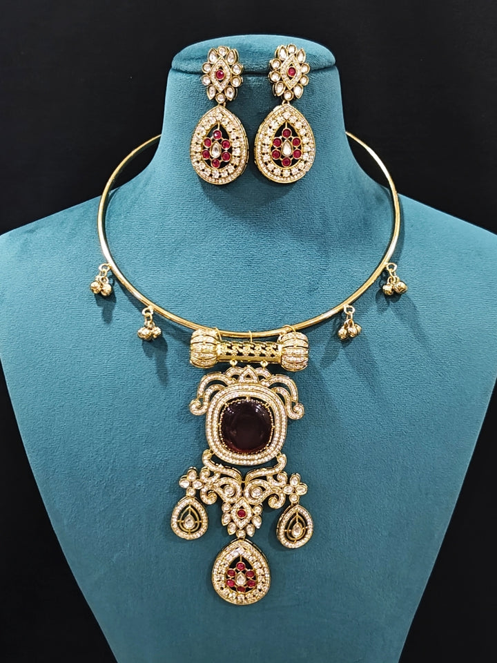 Close-up of an ornate Traditional Red Diamond (Mehendi gold Polish) Hasli jewellery set and earrings with American Diamond and Red Colored Stones. A  luxury American diamond necklace set styled beautifully for a wedding guest look in India. Elegant festive look with a high-quality imitation American diamond necklace set.