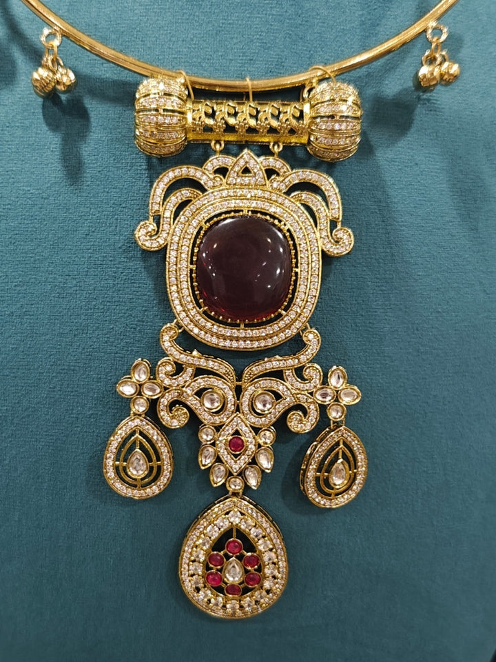 Close-up of an ornate Traditional Red Diamond (Mehendi gold Polish) Hasli jewellery set and earrings with American Diamond and Red Colored Stones. A  luxury American diamond necklace set styled beautifully for a wedding guest look in India. Elegant festive look with a high-quality imitation American diamond necklace set.