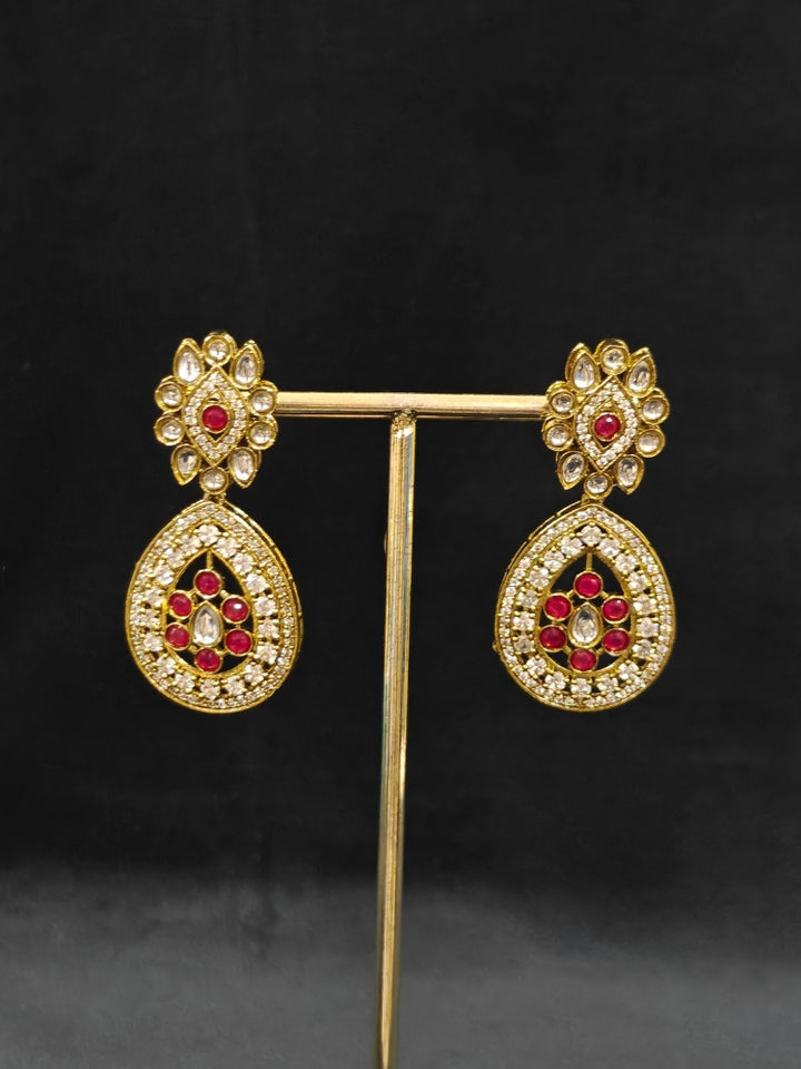 Close-up of an ornate Traditional Red Diamond (Mehendi gold Polish) Hasli jewellery set and earrings with American Diamond and Red Colored Stones. A  luxury American diamond necklace set styled beautifully for a wedding guest look in India. Elegant festive look with a high-quality imitation American diamond necklace set.