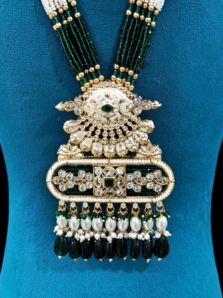 Close-up of an ornate traditional Green Rajwadi gold Long jewellery set and earrings  with  Pearls, Tumble Beads, Meenakari, Moissanite Kundan, Bandhai Work and Hydro Crystals. Close-up of detailed Rajwadi craftsmanship in artificial jewelry. Festive look completed with a luxury Rajwadi imitation necklace.