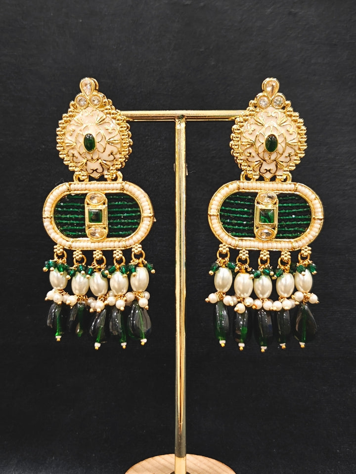 Close-up of an ornate traditional Green Rajwadi gold Long jewellery set and earrings  with  Pearls, Tumble Beads, Meenakari, Moissanite Kundan, Bandhai Work and Hydro Crystals. Close-up of detailed Rajwadi craftsmanship in artificial jewelry. Festive look completed with a luxury Rajwadi imitation necklace.