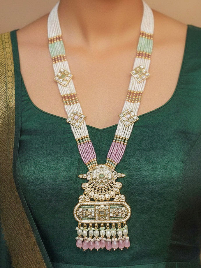 Close-up of a woman wearing an ornate traditional Mint Pink and Green Rajwadi gold Long jewellery set and earrings  with  Pearls, Tumble Beads, Meenakari, Moissanite Kundan, Bandhai Work and Hydro Crystals. Woman wearing a Rajwadi necklace for a reception function. Elegant  look with a traditional Rajwadi artificial necklace.