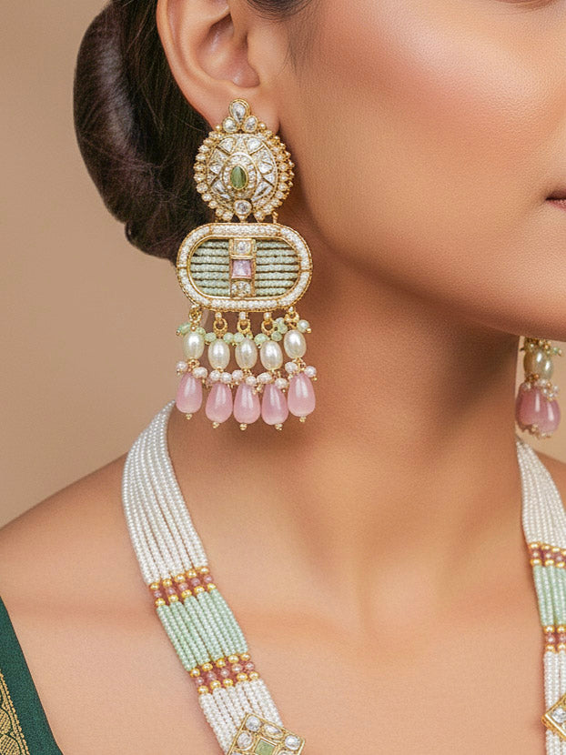Close-up of a woman wearing an ornate traditional Mint Pink and Green Rajwadi gold Long jewellery set and earrings  with  Pearls, Tumble Beads, Meenakari, Moissanite Kundan, Bandhai Work and Hydro Crystals. Woman wearing a Rajwadi necklace for a reception function. Elegant  look with a traditional Rajwadi artificial necklace.