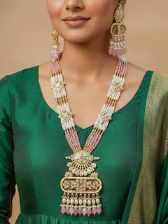 Close-up of a woman wearing an ornate traditional Mint Pink Rajwadi gold Long jewellery set and earrings  with  Pearls, Tumble Beads, Meenakari, Moissanite Kundan, Bandhai Work and Hydro Crystals. Festive look completed with a luxury Rajwadi imitation necklace. Close-up of a premium Rajwadi artificial necklace under 10000. Perfect Rajwadi necklace set for weddings and festivals.