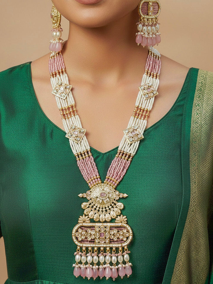 Close-up of a woman wearing an ornate traditional Mint Pink Rajwadi gold Long jewellery set and earrings  with  Pearls, Tumble Beads, Meenakari, Moissanite Kundan, Bandhai Work and Hydro Crystals. Festive look completed with a luxury Rajwadi imitation necklace. Close-up of a premium Rajwadi artificial necklace under 10000. Perfect Rajwadi necklace set for weddings and festivals.