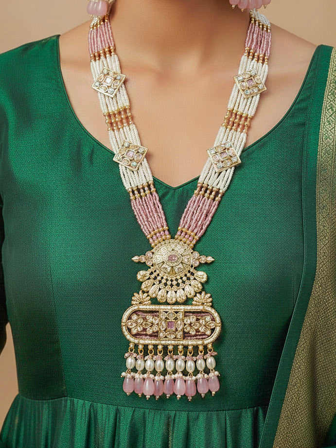 Close-up of a woman wearing an ornate traditional Mint Pink Rajwadi gold Long jewellery set and earrings  with  Pearls, Tumble Beads, Meenakari, Moissanite Kundan, Bandhai Work and Hydro Crystals. Festive look completed with a luxury Rajwadi imitation necklace. Close-up of a premium Rajwadi artificial necklace under 10000. Perfect Rajwadi necklace set for weddings and festivals.
