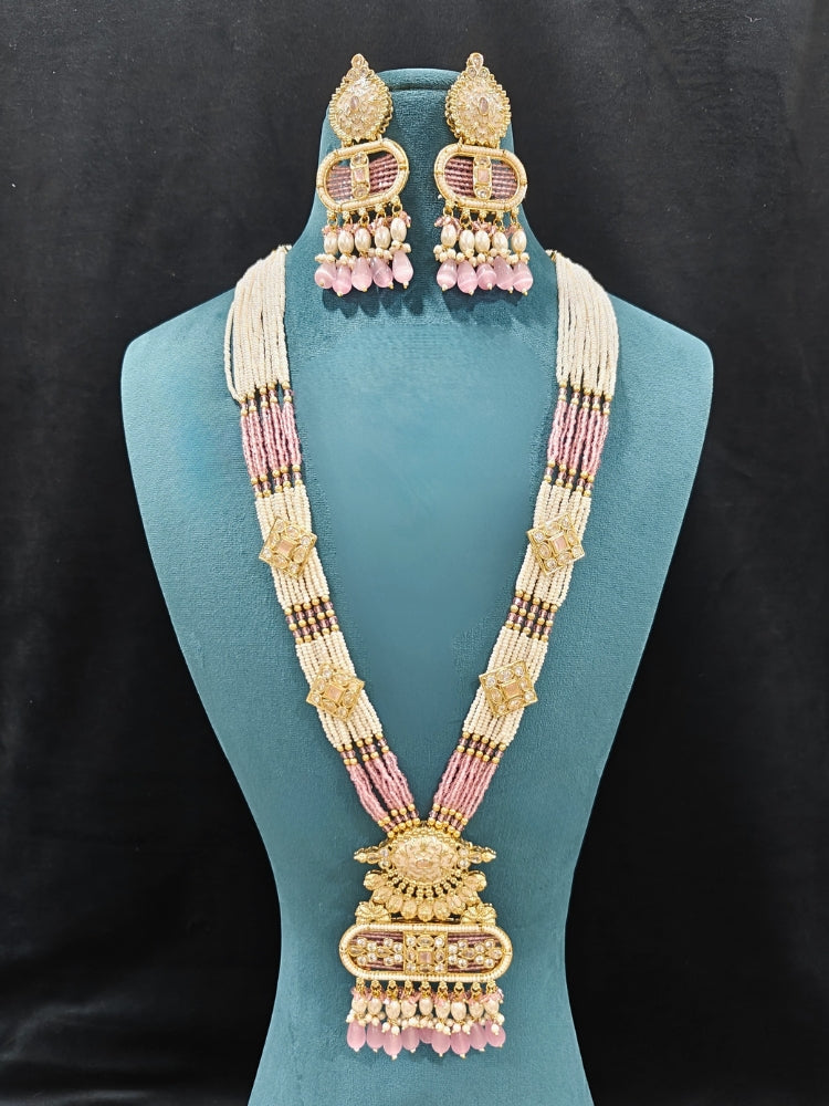 Close-up of an ornate traditional Mint Pink Rajwadi gold Long jewellery set and earrings  with  Pearls, Tumble Beads, Meenakari, Moissanite Kundan, Bandhai Work and Hydro Crystals. Festive look completed with a luxury Rajwadi imitation necklace.  Perfect Rajwadi necklace set for weddings and festivals.