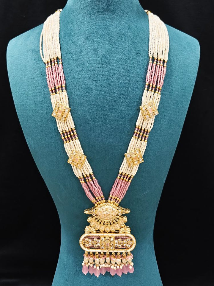 Close-up of an ornate traditional Mint Pink Rajwadi gold Long jewellery set and earrings  with  Pearls, Tumble Beads, Meenakari, Moissanite Kundan, Bandhai Work and Hydro Crystals. Festive look completed with a luxury Rajwadi imitation necklace.  Perfect Rajwadi necklace set for weddings and festivals.