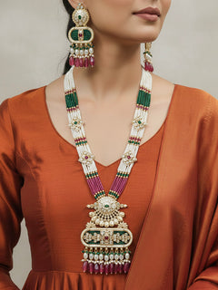 Close-up of a woman wearing an ornate traditional Ruby Pink and Green Rajwadi gold Long jewellery set and earrings  with  Pearls, Tumble Beads, Meenakari, Moissanite Kundan, Bandhai Work and Hydro Crystals. Woman wearing a Rajwadi necklace for a reception function. Wedding guest styling a Rajwadi artificial necklace with a Anarkali.