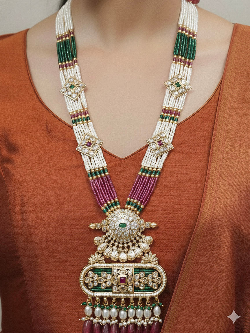 Close-up of a woman wearing an ornate traditional Ruby Pink and Green Rajwadi gold Long jewellery set and earrings  with  Pearls, Tumble Beads, Meenakari, Moissanite Kundan, Bandhai Work and Hydro Crystals. Woman wearing a Rajwadi necklace for a reception function. Wedding guest styling a Rajwadi artificial necklace with a Anarkali.