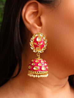 Close-up of a woman wearing an ornate traditional Magenta Meenakari gold Earrings with Pearls, Kundan and Meenakari. Festive Diwali look styled with premium artificial Meenakari earrings. Close-up of anti-tarnish artificial Meenakari earrings for festive celebrations.