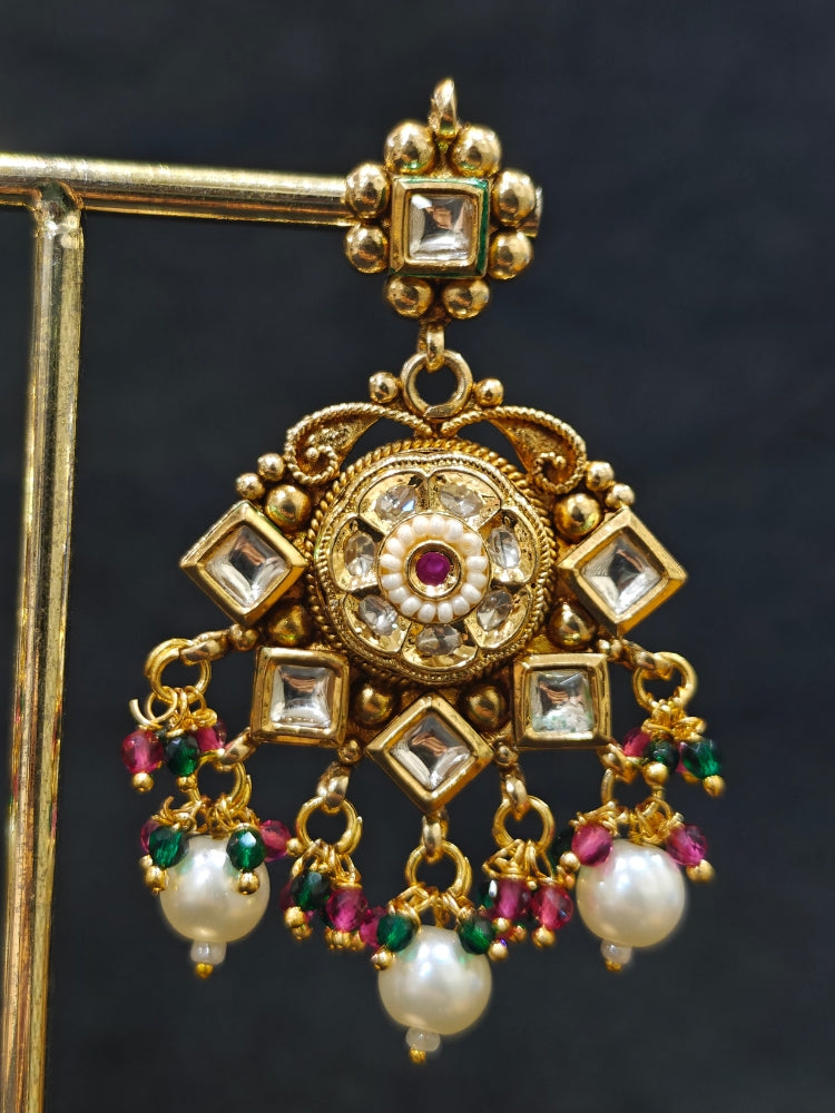 Close-up of an ornate traditional Rajwadi and Heritage gold Choker jewellery set and earrings and maangtikka with Pearls, Hydro Crystal and Moissanite Kundan. Close-up of a premium Rajwadi artificial necklace. Traditional Indian bridal look completed with a heritage artificial jewelry set.