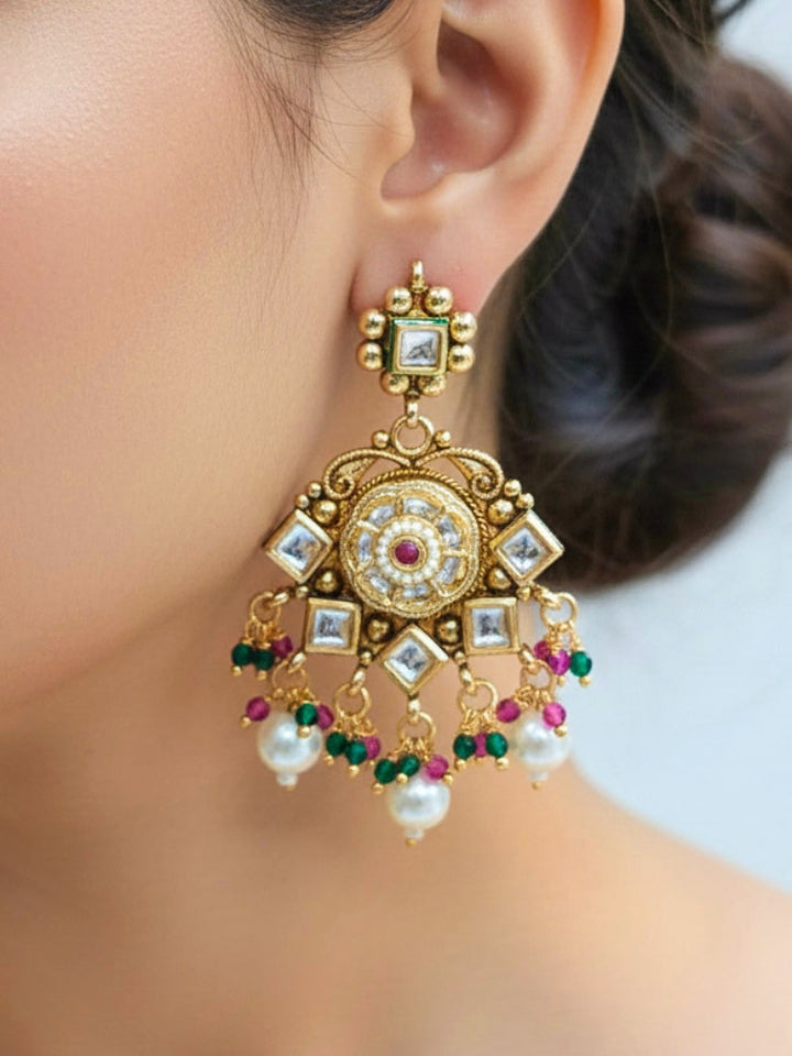 Close-up of a woman wearing an ornate traditional Rajwadi and Heritage gold Choker jewellery set and earrings and maangtikka with Pearls, Hydro Crystal and Moissanite Kundan. Bride wearing a premium Rajwadi necklace with a Lehenga for her reception. Royal bridal look completed with a statement heritage necklace set.