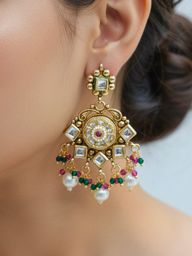 Close-up of a woman wearing an ornate traditional Rajwadi and Heritage gold Choker jewellery set and earrings and maangtikka with Pearls, Hydro Crystal and Moissanite Kundan. Bride wearing a premium Rajwadi necklace with a Lehenga for her reception. Royal bridal look completed with a statement heritage necklace set.