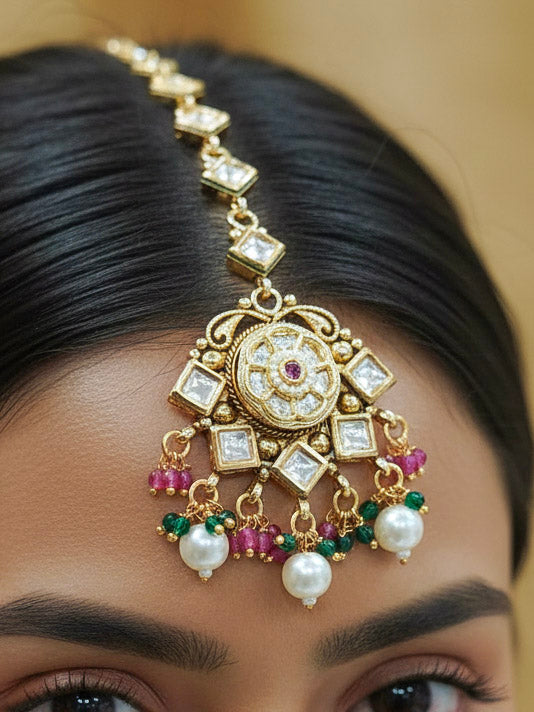Close-up of a woman wearing an ornate traditional Rajwadi and Heritage gold Choker jewellery set and earrings and maangtikka with Pearls, Hydro Crystal and Moissanite Kundan. Bride wearing a premium Rajwadi necklace with a Lehenga for her reception. Royal bridal look completed with a statement heritage necklace set.