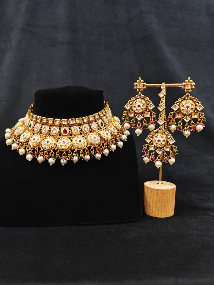 Close-up of an ornate traditional Rajwadi and Heritage gold Choker jewellery set and earrings and maangtikka with Pearls, Hydro Crystal and Moissanite Kundan. Close-up of a premium Rajwadi artificial necklace. Traditional Indian bridal look completed with a heritage artificial jewelry set.