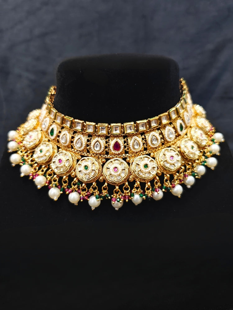 Close-up of an ornate traditional Rajwadi and Heritage gold Choker jewellery set and earrings and maangtikka with Pearls, Hydro Crystal and Moissanite Kundan. Close-up of a premium Rajwadi artificial necklace. Traditional Indian bridal look completed with a heritage artificial jewelry set.