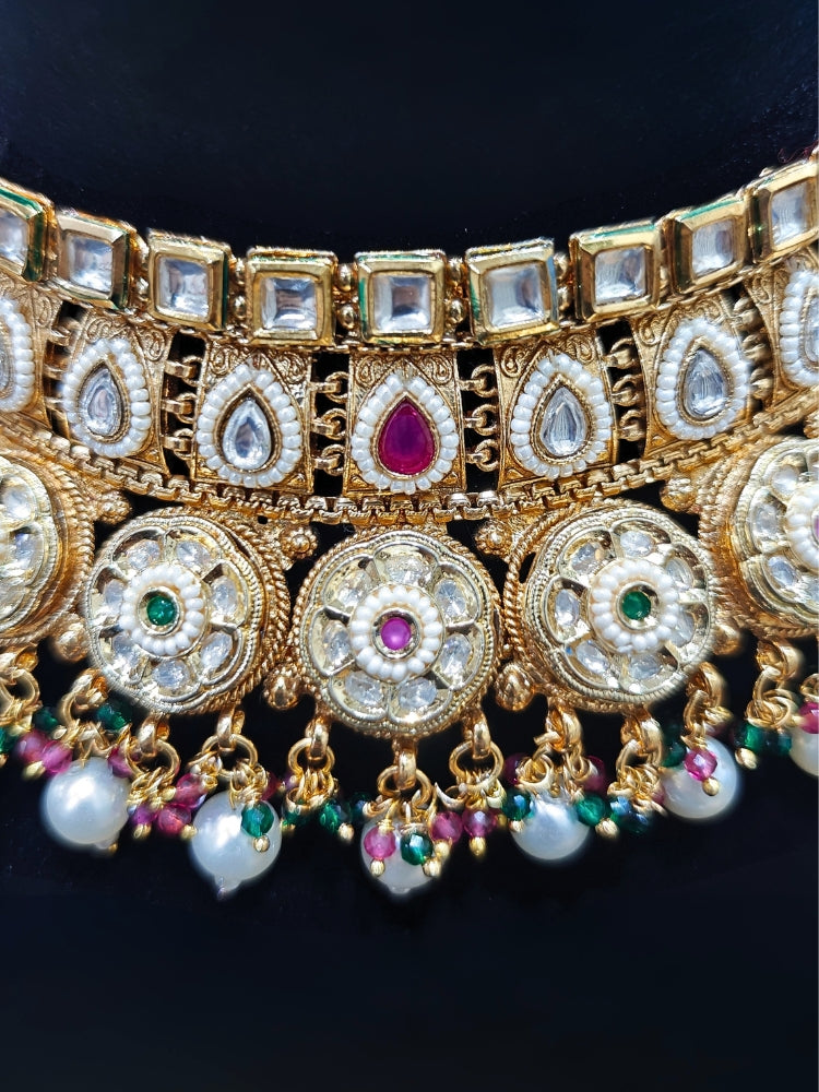 Close-up of an ornate traditional Rajwadi and Heritage gold Choker jewellery set and earrings and maangtikka with Pearls, Hydro Crystal and Moissanite Kundan. Close-up of a premium Rajwadi artificial necklace. Traditional Indian bridal look completed with a heritage artificial jewelry set.