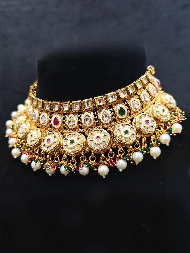 Close-up of an ornate traditional Rajwadi and Heritage gold Choker jewellery set and earrings and maangtikka with Pearls, Hydro Crystal and Moissanite Kundan. Close-up of a premium Rajwadi artificial necklace. Traditional Indian bridal look completed with a heritage artificial jewelry set.