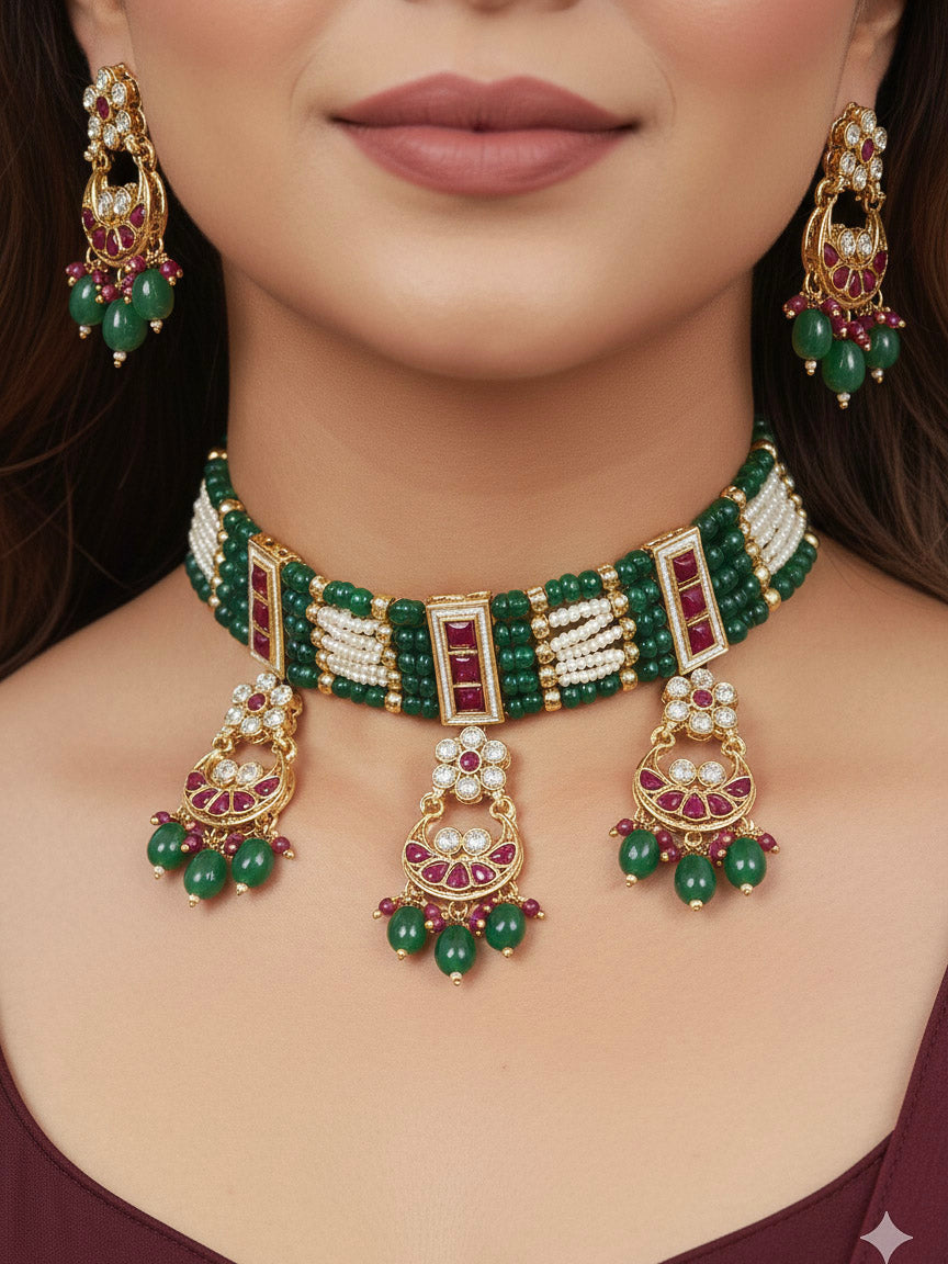 Close-up of a woman wearing an ornate traditional (Gold Polish) Green and Pink  Choker jewellery set and earrings and maangtikka with Pearls, Beads, Pink Colored Stones, Bandhai Work, Tumble Beads. Mehendi ceremony look completed with a handcrafted Colored Stone jewelry set. Woman styling a vibrant Colored Stone necklace with a festive saree.