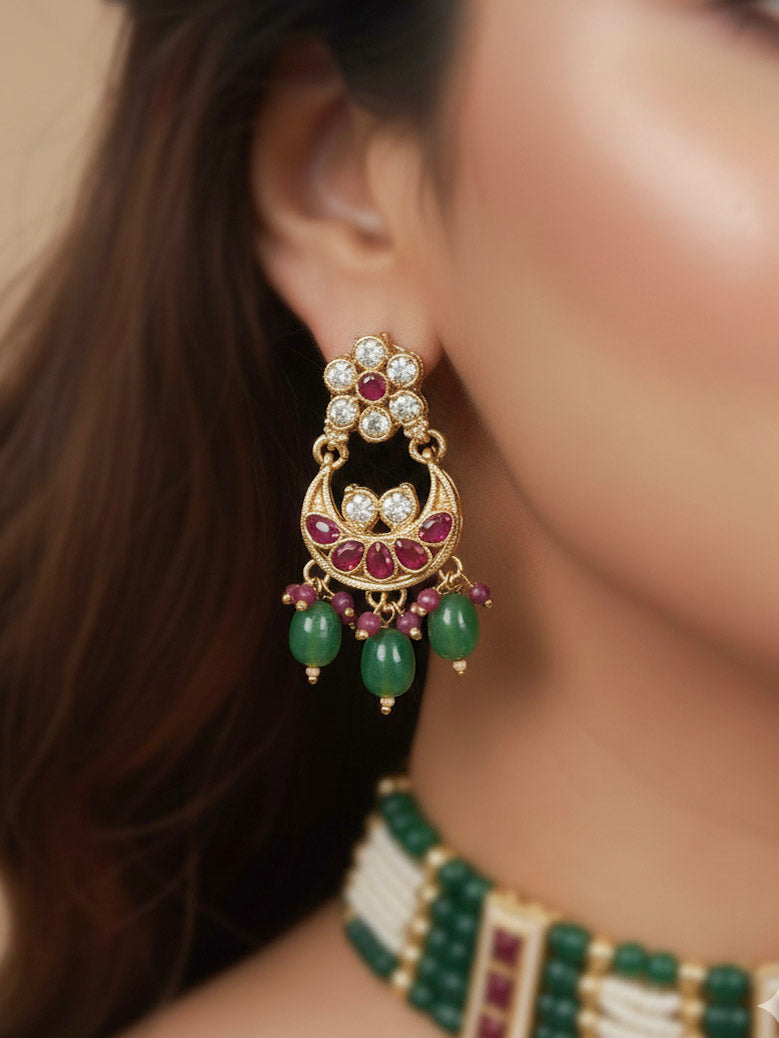 Close-up of a woman wearing an ornate traditional (Gold Polish) Green and Pink  Choker jewellery set and earrings and maangtikka with Pearls, Beads, Pink Colored Stones, Bandhai Work, Tumble Beads. Mehendi ceremony look completed with a handcrafted Colored Stone jewelry set. Woman styling a vibrant Colored Stone necklace with a festive saree.