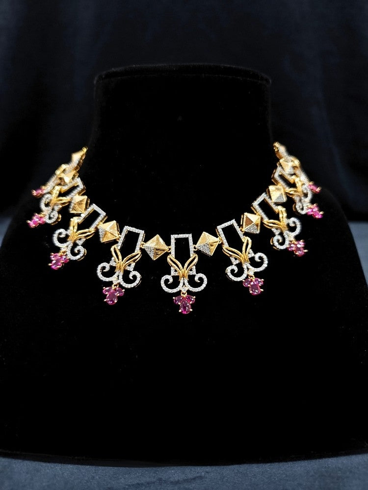 Close-up of an ornate Indo-western American Diamond Ruby Pink Gold Collar jewellery set and earrings with American Diamond and Ruby Pink Colored Stones. Party wear outfit completed with a lightweight American diamond necklace. 