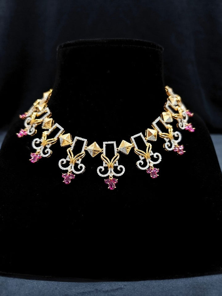 Close-up of an ornate Indo-western American Diamond Ruby Pink Gold Collar jewellery set and earrings with American Diamond and Ruby Pink Colored Stones. Party wear outfit completed with a lightweight American diamond necklace. 
