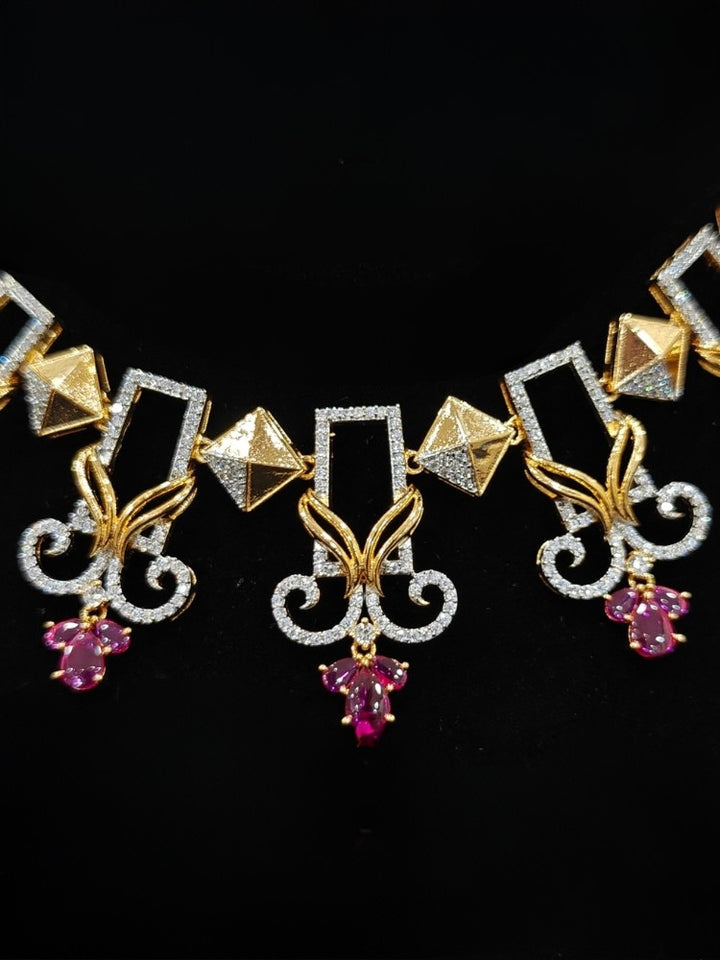 Close-up of an ornate Indo-western American Diamond Ruby Pink Gold Collar jewellery set and earrings with American Diamond and Ruby Pink Colored Stones. Party wear outfit completed with a lightweight American diamond necklace. 