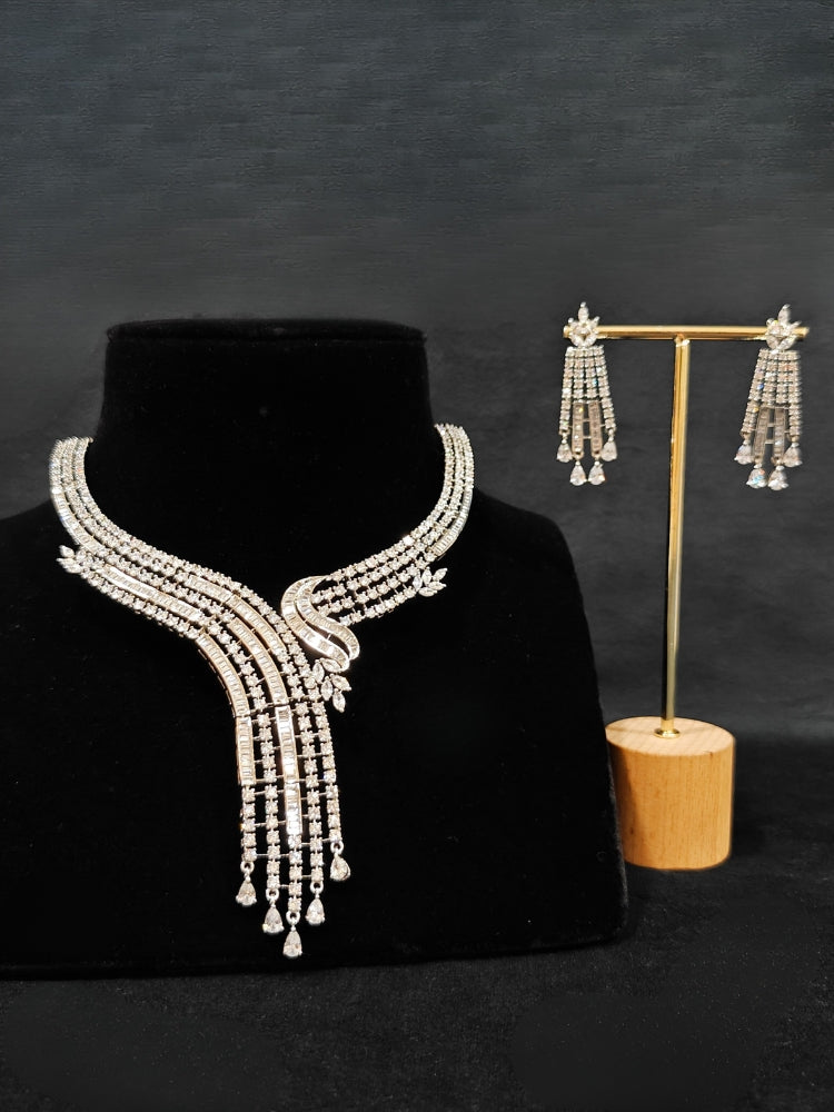 Close-up of an ornate Western Silver Diamond Collar jewellery set and earrings with American Diamond. Close-up of a cocktail party look featuring a premium American diamond necklace. A luxury American diamond necklace set styled beautifully for a wedding guest look in India.