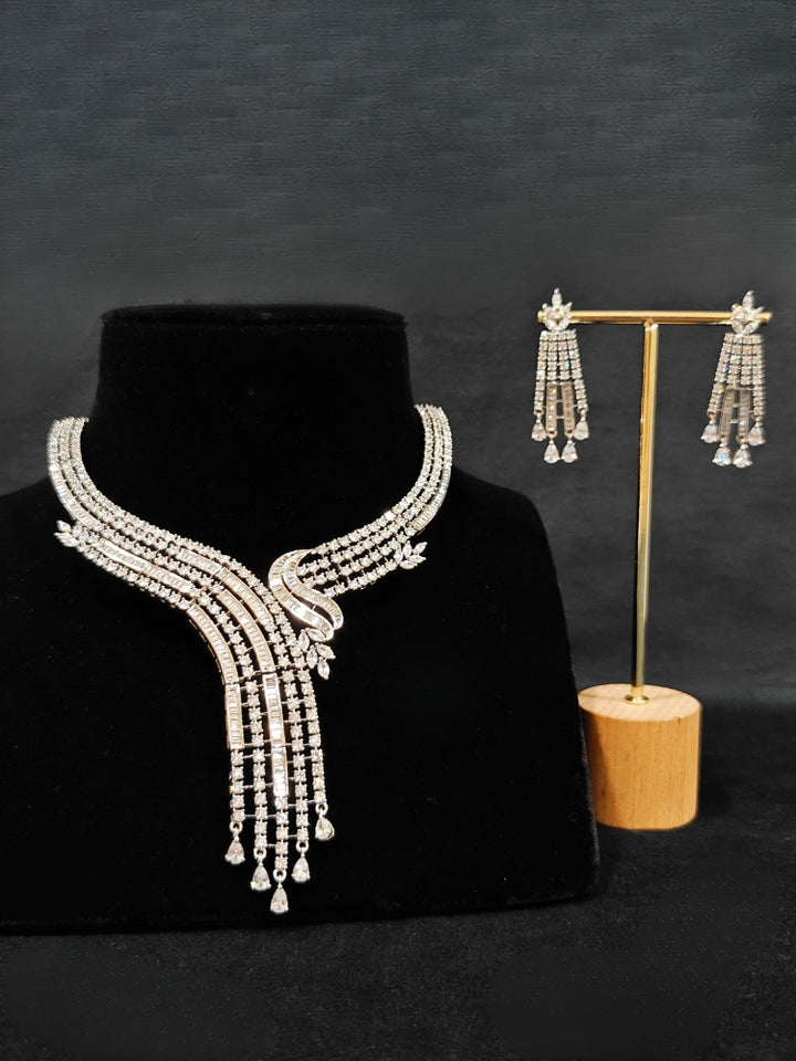 Close-up of an ornate Western Silver Diamond Collar jewellery set and earrings with American Diamond. Close-up of a cocktail party look featuring a premium American diamond necklace. A luxury American diamond necklace set styled beautifully for a wedding guest look in India.