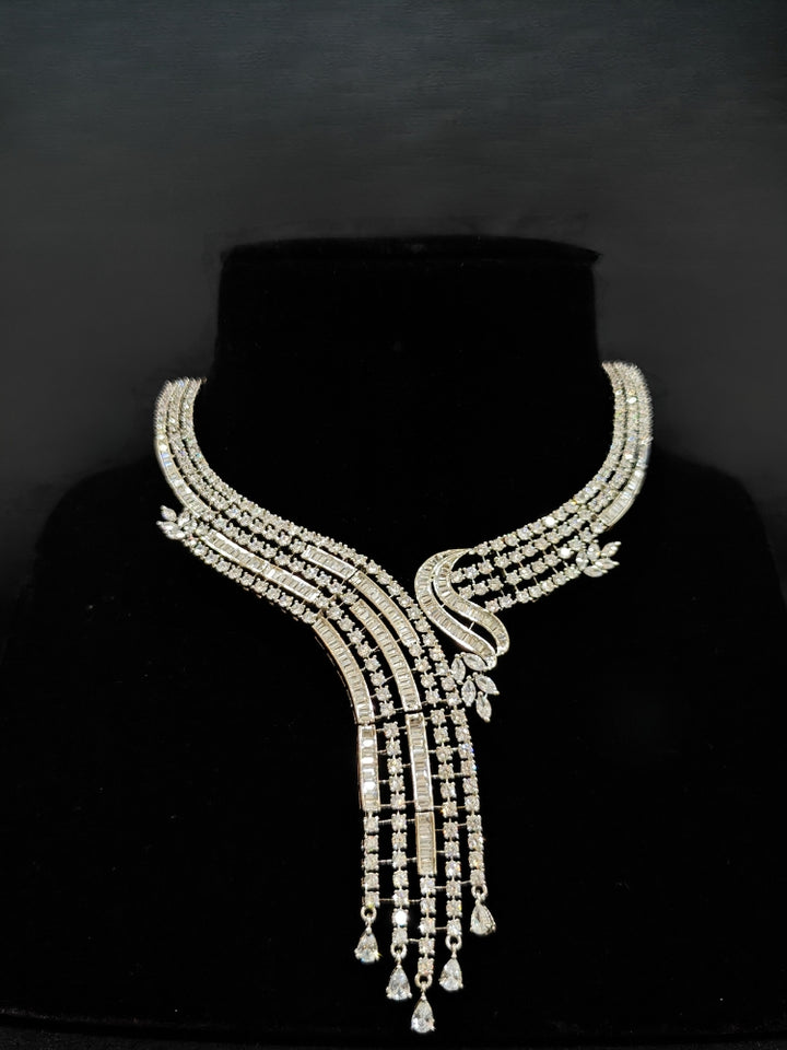 Close-up of an ornate Western Silver Diamond Collar jewellery set and earrings with American Diamond. Close-up of a cocktail party look featuring a premium American diamond necklace. A luxury American diamond necklace set styled beautifully for a wedding guest look in India.