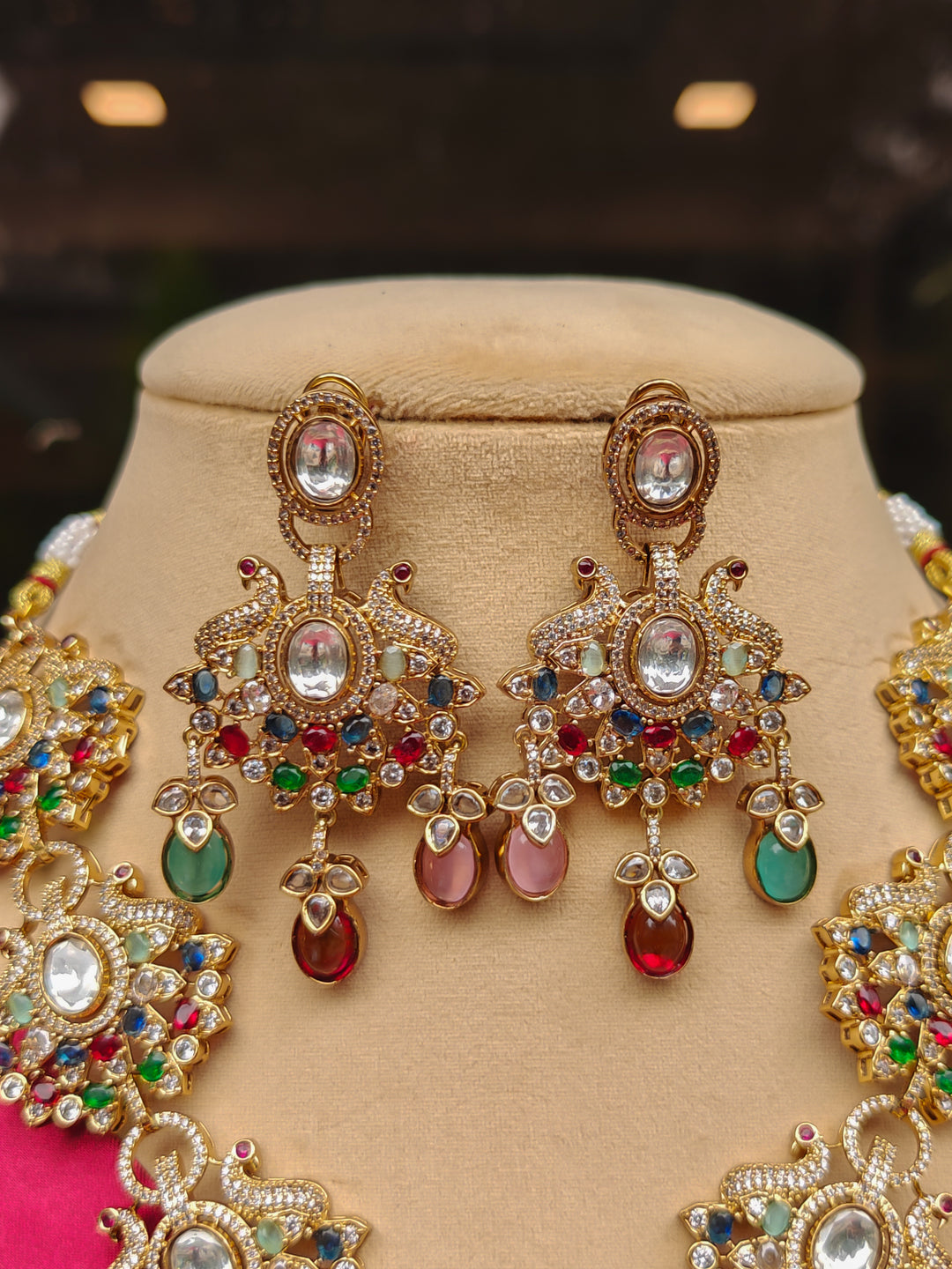 Close-up of an ornate traditional American diamond & Color stone gold jewellery set and earrings with American Diamond, Colored Stones, Kundan and Polki. A graceful trending American diamond necklace for a 2026 wedding celebration.