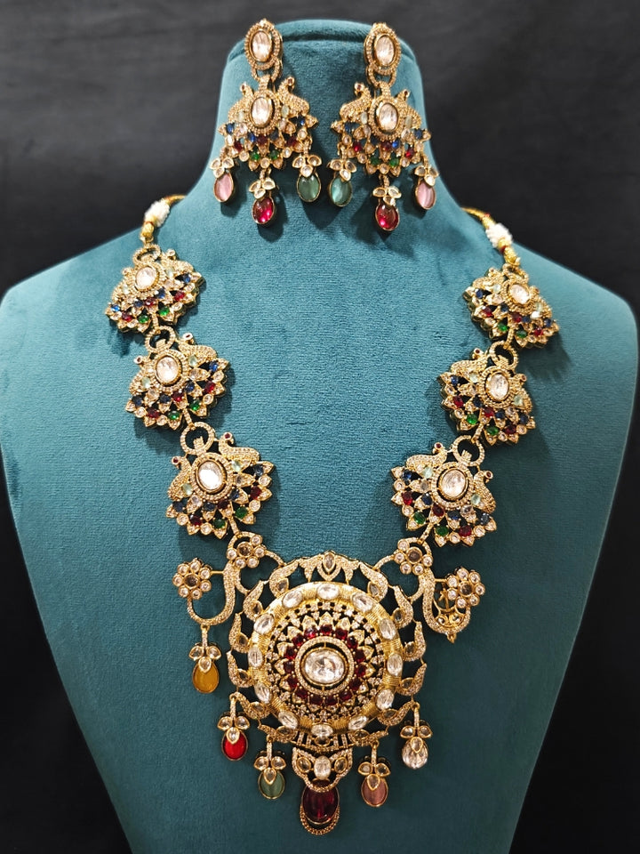 Close-up of an ornate traditional American diamond & Color stone gold jewellery set and earrings with American Diamond, Colored Stones, Kundan and Polki. A graceful trending American diamond necklace for a 2026 wedding celebration.