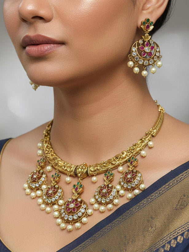 Close-up of a woman wearing an ornate traditional (Gold Polish) Hasli Collar Jewellery Set and Earrings with American Diamond, Colored Stones and Pearls. Woman wearing lightweight artificial American Diamond Hasli jewelry for long wedding functions. Woman wearing Hasli American Diamond artificial jewelry for a grand celebration.