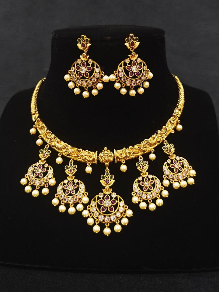Close-up of a woman wearing an ornate traditional (Gold Polish) Hasli Collar Jewellery Set and Earrings with American Diamond, Colored Stones and Pearls. Woman wearing lightweight artificial American Diamond Hasli jewelry for long wedding functions. Woman wearing Hasli American Diamond artificial jewelry for a grand celebration.